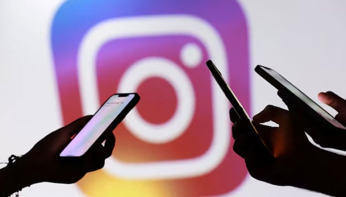 Teenagers pose for a photo while holding smartphones in front of a Facebook logo in this illustration taken September 11, 2025. — Reuters