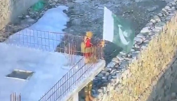 A Pakistan Army soldier raises national flag at a captured Afghan Taliban checkpost at border on February 27, 2026. — X@PTVNewsOfficial