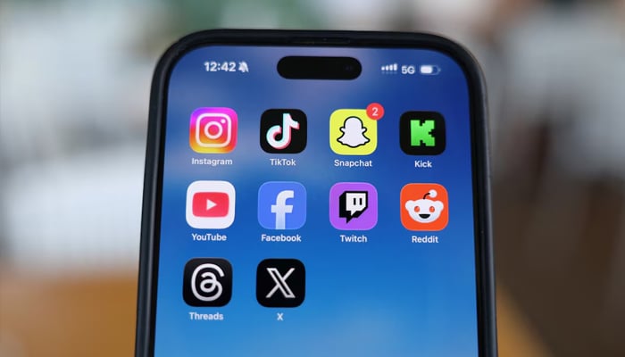 Instagram, TikTok, Snapchat, Kick, YouTube, Facebook, Twitch, Reddit, Threads and X applications are displayed on a mobile phone in this picture illustration taken on December 9, 2025. — Reuters