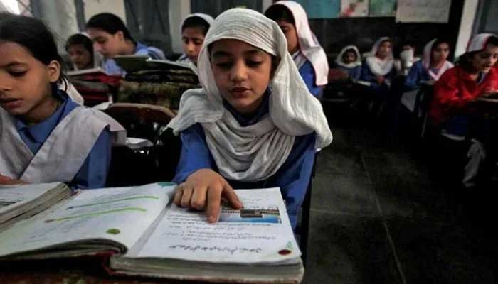 A girl reads a book while attending her daily class with others at a government school. — Reuters/File