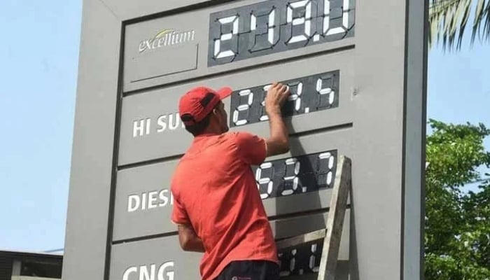 A petrol pump worker changing the price of petroleum products in this undated picture. — AFP/File