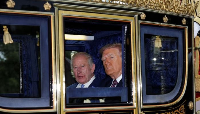 Britains King Charles and US President Donald Trump sit in a carriage during a procession through Windsor Castle, in Windsor, Britain, September 17, 2025. — Reuters