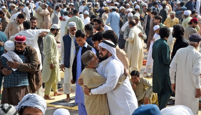 People greet each other after offering prayers of Eid ul Fitr at the Eidgah Sharif shrine in Rawalpindi. — Online/File