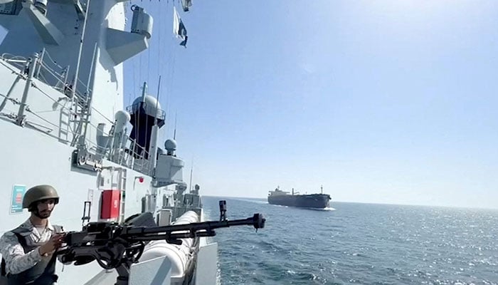A PN ship escorts a Pakistani merchant vessel, as part of a maritime security operation, named Muhafiz-ul-Bahr, as regional tensions threaten key sea routes, amid the US-Israeli conflict with Iran, at an unidentified location, released on March 9, 2026. — Reuters