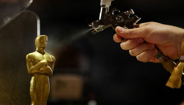 A person spray paints an Oscar-shaped chocolate statue during a media preview of the food, beverages and decor for this years Governors Ball, the official post-Oscars celebration of the Academy of Motion Picture Arts and Sciences (AMPAS), ahead of the 98th Academy Awards ceremony in Los Angeles, California, US, March 10, 2026. — Reuters