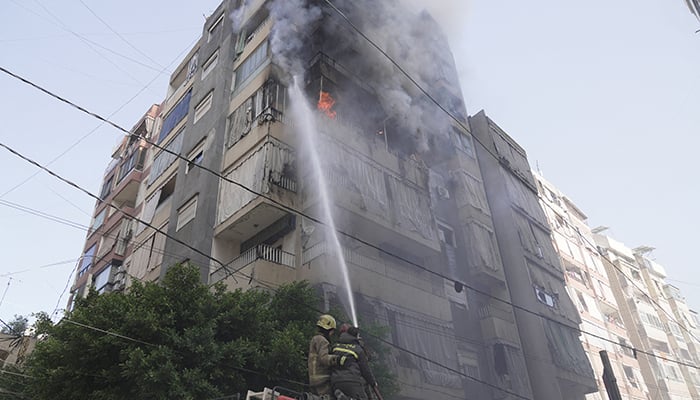 Members of the Lebanese Civil Defence work to extinguish a fire in a building after an Israeli strike on Beirut, Lebanon, March 18, 2026. — Reuters