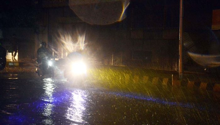 Motorcyclists are on their way during the heavy rain that lashed Karachi, March 18, 2026. — APP