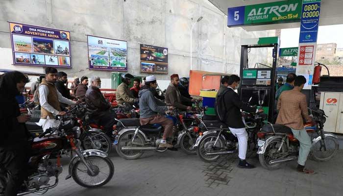 People wait for their turn to get fuel at a petrol station in Peshawar. — Reuters/File