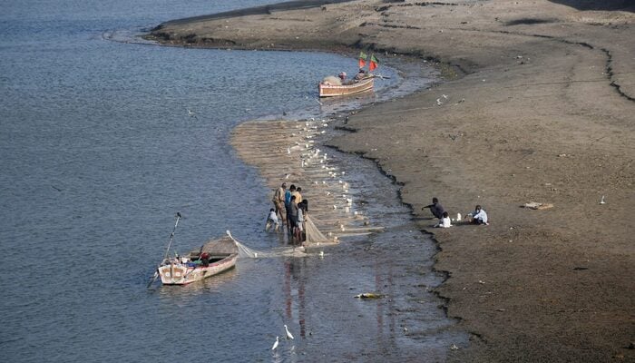 Fishermen clear a fishing net in the water on the partially dried up riverbed of the Indus River in Hyderabad, Pakistan April 25, 2025. — Reuters