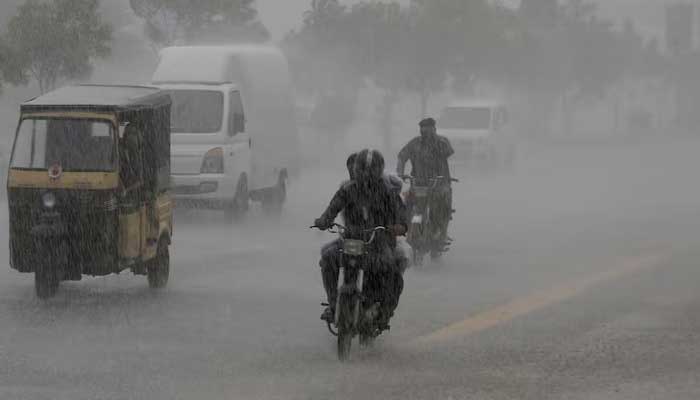 Commuters travel on a road during heavy rain in Karachi, August 20, 2025. — Reuters