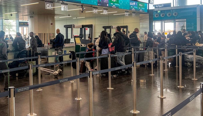 Travelers queue to check-in their luggage at the terminal at King Khalid International Airport in Riyadh on March 10, 2026. — AFP