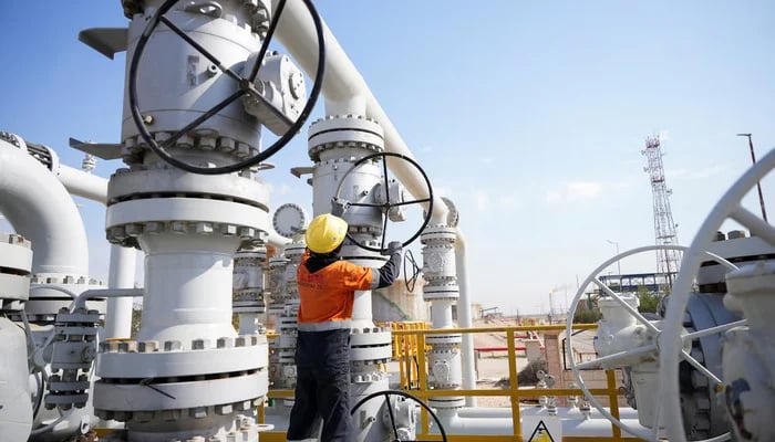 A worker operates valves at the Rumaila oil field, as the country cuts nearly 1.5 million barrels per day of output amid halted exports following the closure of the Strait of Hormuz, in Basra, Iraq, March 4, 2026. — Reuters