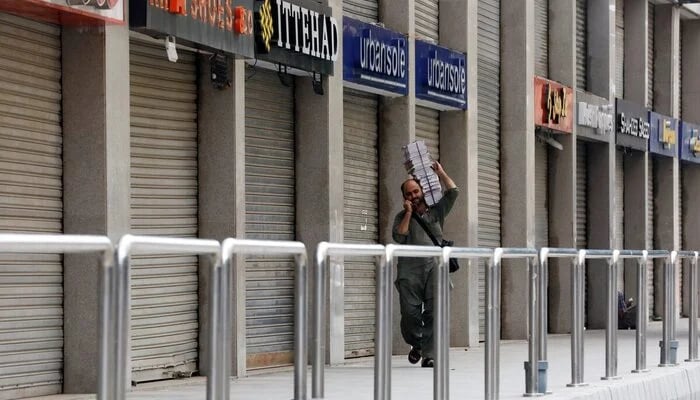 A man walks past closed market during a partial lockdown after Sindh provincial government decided to impose a lockdown in Karachi, July 30, 2021. — Reuters