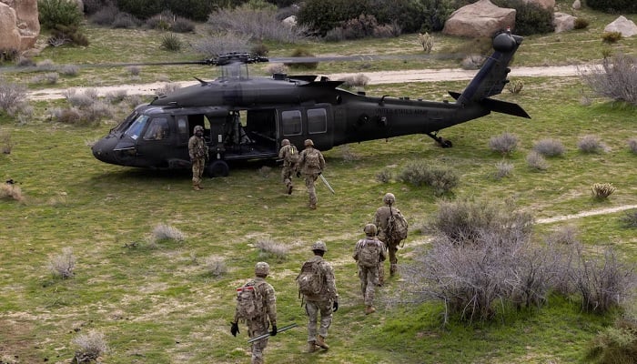 Soldiers assigned to Joint Task Force Southern Border load onto a UH-60 Black Hawk helicopter during a National Defence Area signage emplacement operation in Imperial County, California, January 6, 2026. —www.war.gov