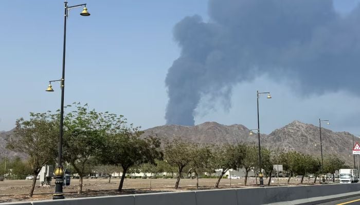 Smoke rises in the Fujairah oil industry zone, caused by debris after interception of a drone by air defenses, according to the Fujairah media office, amid the US-Israel conflict with Iran, in Fujairah, United Arab Emirates, March 14, 2026. — Reuters