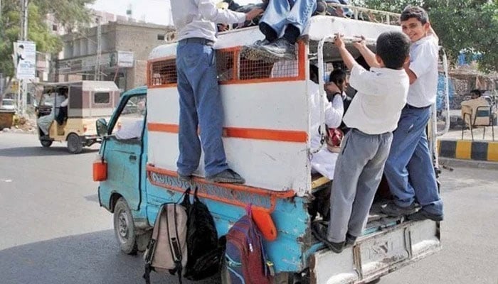 A view of overload school van as a large number of students traveling on the rooftop of a van in a risky manner, posing a potential safety hazard. — Twitter/File