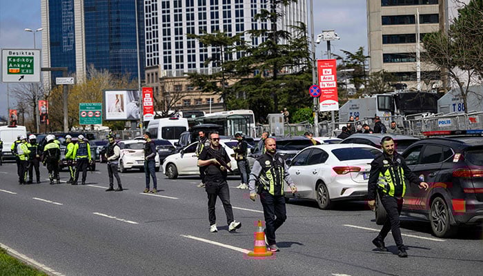 Police officials stand amongst traffic as they patrol near The Israeli Consulate in Istanbul on April 7, 2026, following a shootout between gunmen and police. — AFP