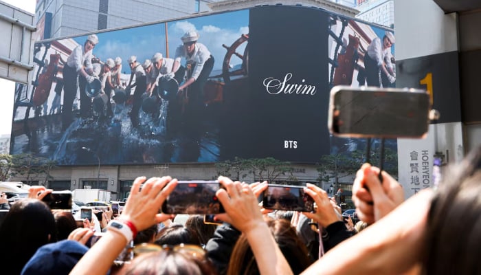 Fans of Kpop boy band BTS, a fanbase known as Army, record BTS newly realeased music video of their new song Swim, ahead of the band’s upcoming free comeback concert, BTS The Comeback Live Arirang, the bands first performance in more than three years since completing mandatory military service, in Seoul, South Korea, March 20, 2026. — Reuters