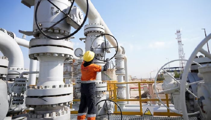 A workers adjusts flow of oil at a refinery. — Reuters/File