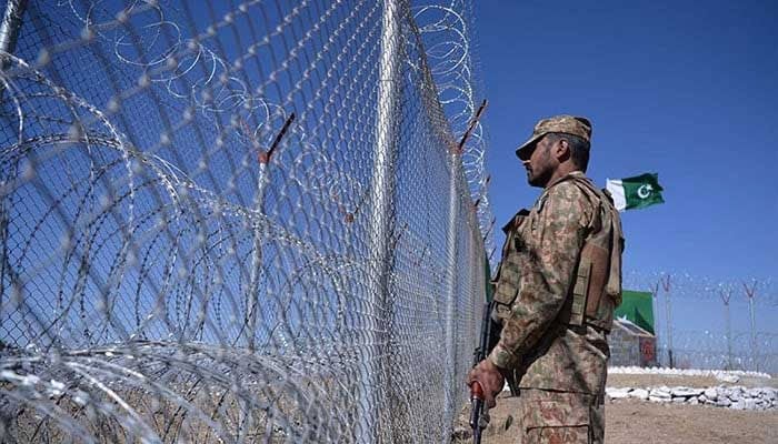 A Pakistan Army soldier stands next to a border fence along Afghanistans Paktika province in Angoor Adda — AFP/File
