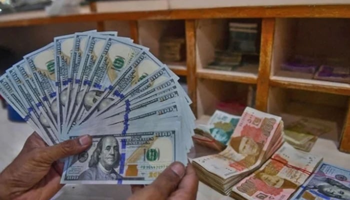 A foreign currency dealer counts US dollars at a shop in Karachi, Pakistan, on May 19, 2022. — AFP/File