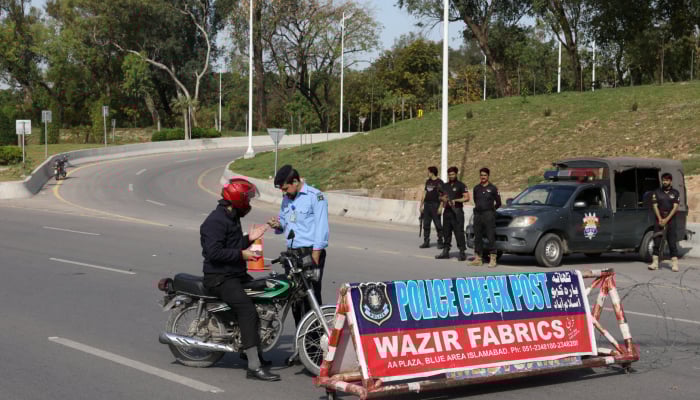 A police officer checks a mans identification at a security check post along a road, as Pakistan prepares to host the US and Iran for the potential second phase of peace talks in Islamabad, Pakistan, April 19, 2026. — Reuters