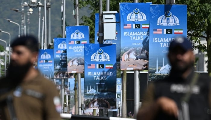 Security personnel stand guard at a security checkpost along a road temporarily closed near the Serena Hotel at the Red Zone area in Islamabad, April 20, 2026. — AFP