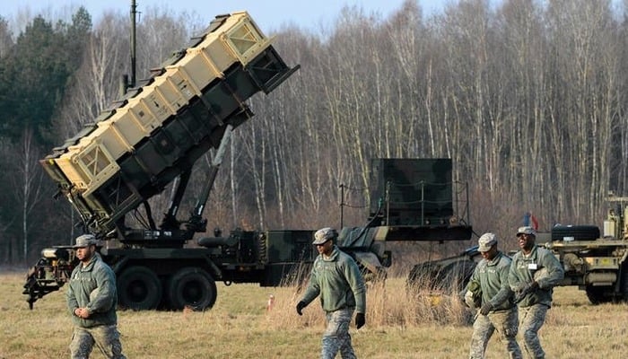 US soldiers walk next to a Patriot missile defence battery near Warsaw. — AFP