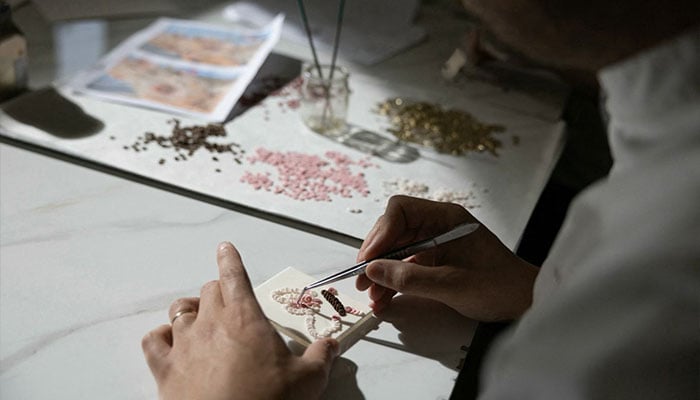 French pastry chef Bastien Blanc-Tailleur creates decorations for a wedding cake at his studio in Saint-Remy-les-Chevreuse, southwestern Paris on April 10, 2026. — AFP
