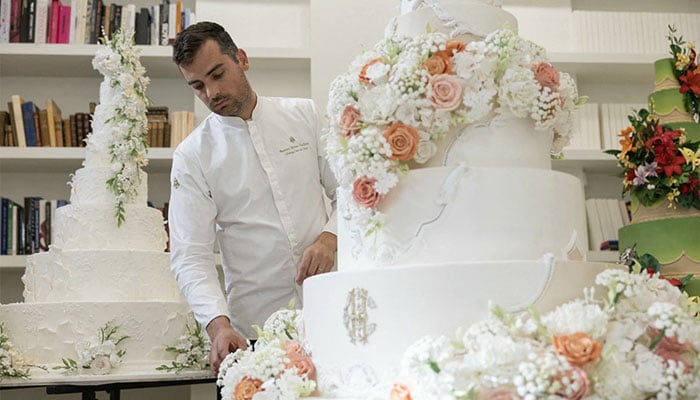 French pastry chef Bastien Blanc-Tailleur decorates a wedding cake at his studio in Saint-Remy-les-Chevreuse, southwestern Paris on April 10, 2026. — AFP