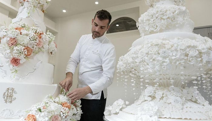 French pastry chef Bastien Blanc-Tailleur decorates a wedding cake at his studio in Saint-Remy-les-Chevreuse. — AFP
