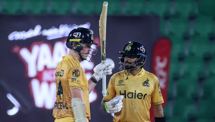 Peshawar Zalmis Michael Bracewell (left) raises his bat after completing his half-century alongside Babar Azam (right) during the PSL 11 match against Lahore Qalandars at Gaddafi Stadium in Lahore on April 25, 2026. — PSL