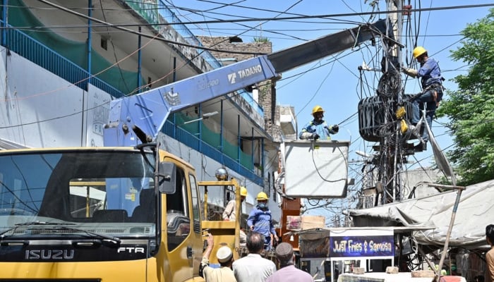Wapda staffers are busy replacing a power transformer on electric poles at Khyban-e-Sir Syed in Rawalpindi, April 6, 2026. — APP