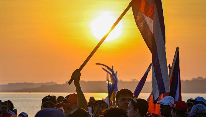 A man marches holding a Cuban national flag along Havanas waterfront to mark International Workers Day at the Anti-Imperialist Platform in front of the US Embassy in Havana, Cuba, on May 1, 2026. — AFP