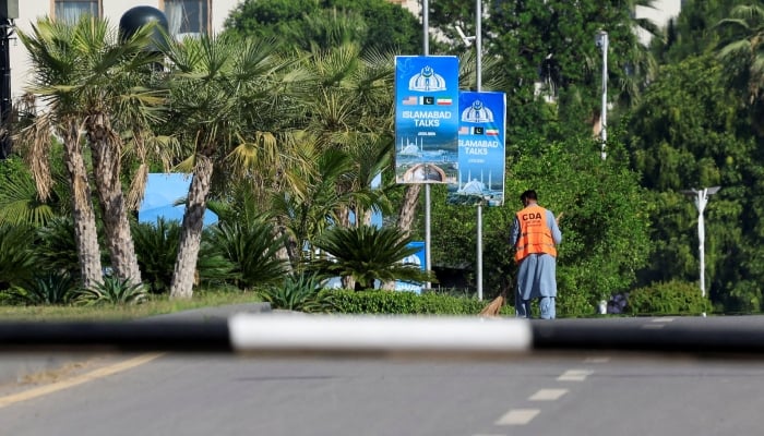 A worker cleans a road at the premises of Convention Centre in Islamabad, April 22, 2026. — Reuters