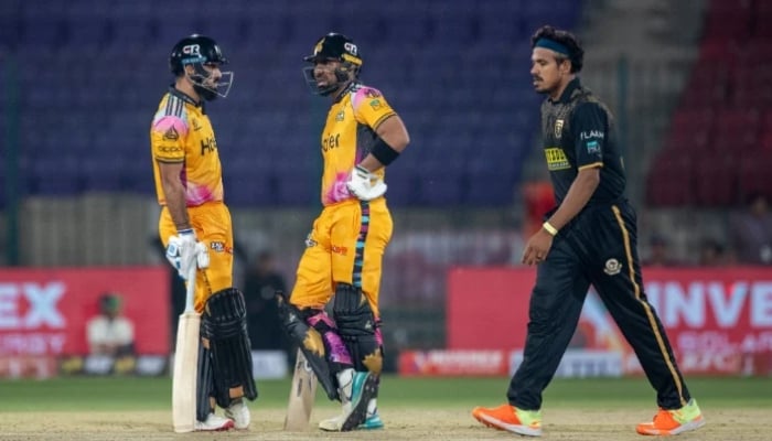 Peshawar Zalmi batters Aamer Jamal (left) and Iftikhar Ahmed (centre) engage in a discussion while Hyderabad Kingsmen spinner Maheesh Theekshana walks in to deliver his spell during their PSL 11 match at the National Bank Stadium, Karachi, April 8, 2026. — PSL