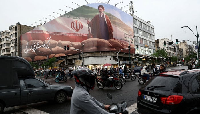 People ride motorcycles near a billboard featuring an image of Irans new Supreme Leader Mojtaba Khamenei, amid a ceasefire between US and Iran, in Tehran, Iran, April 20, 2026. — Reuters