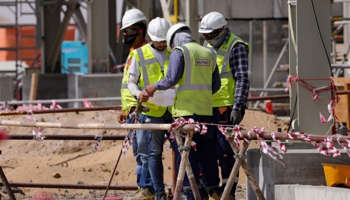 Workers are pictured next to a waste management facility under construction at the Beeah company in Sharjah, UAE. — AFP/File