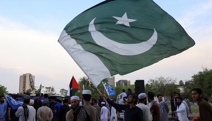 A man waves Pakistans flag as he along with others gather in support of Pakistan Army, day after the ceasefire announcement between India and Pakistan, in Islamabad, May 11, 2025. — Reuters
