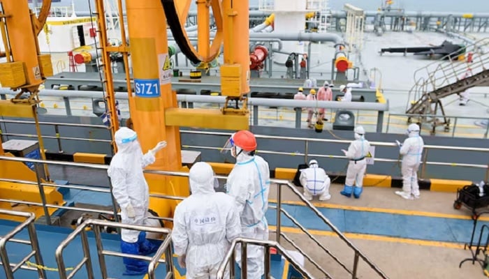 Immigration inspection officers in protective suits check a tanker carrying imported crude oil at the port in Qingdao, Shandong province, China, May 9, 2022. — Reuters