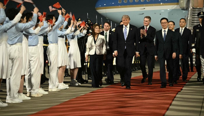 US President Donald Trump (Centre), US Ambassador To china David Perdue (centre-R) escorted by Chinas Vice President Han Zheng (right) are greeted by Chinese youth upon arriving at Beijing Capital Airport in Beijing on May 13, 2026. — AFP