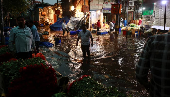 A man wades through a waterlogged street in a wholesale market after rain, in New Delhi, India, May 2, 2025. — Reuters