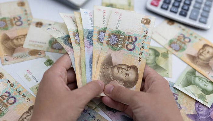 Woman holds Chinese Yuan banknotes in this illustration taken May 30, 2022. — Reuters