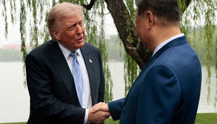 US President Donald Trump (L) is greeted by Chinese President Xi Jinping at Zhongnanhai Garden in Beijing on May 15, 2026. — AFP
