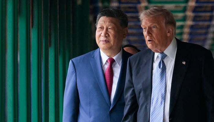 US President Donald Trump (R) walks with Chinas President Xi Jinping at Zhongnanhai Garden in Beijing on May 15, 2026. — AFP