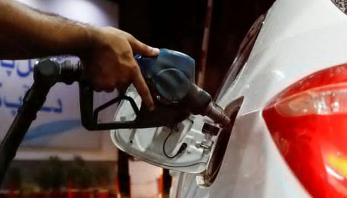 A worker holds a fuel nozzle to fill a car with fuel at a petrol station in Karachi, September 16, 2023. — Reuters