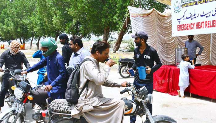 Workers of the Cantonment Board Hyderabad serve chilled drinking water to citizens at a heatstroke relief camp set up on Alamgir Road amid scorching weather conditions.— APP