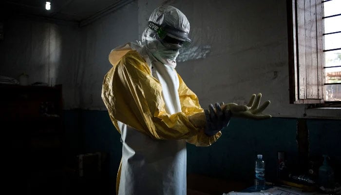 A health worker puts on his personal protective equipment (PPE) before entering the red zone of a MSF (Doctors Without Borders) supported Ebola Treatment Centre (ETC), on November 6, 2018, in Bunia, Democratic Republic of the Congo. — AFP
