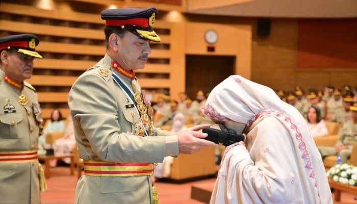 Chief of Defence Forces and Chief Army Staff Field Marshal Syed Asim Munir presents the posthumous medal to a family member of a martyr armed forces personnel during an investiture ceremony at General Headquarters in Rawalpindi, on May 21, 2026. — ISPR