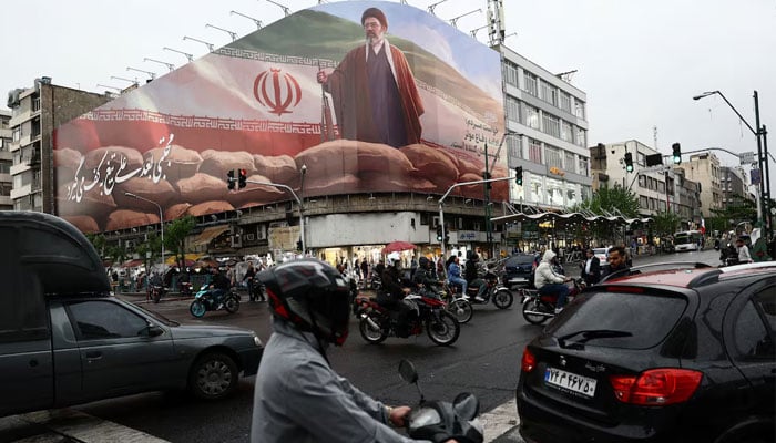 People ride motorcycles near a billboard featuring an image of Irans new Supreme Leader Mojtaba Khamenei, amid a ceasefire between the US and Iran, in Tehran, Iran, April 20, 2026. — Reuters